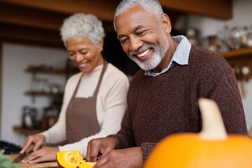 Senior couple preparing pumpkin dish together in kitchen Generative AI