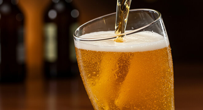 Close-up of craft beer being poured into a frosty glass - Powered by Adobe