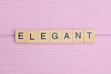  word elegant from gray wooden small letters with black font on an pink background