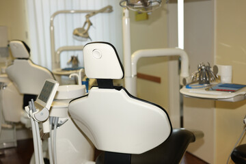 Empty dentist chair in a modern, clean and bright dental clinic, ready for the next patient