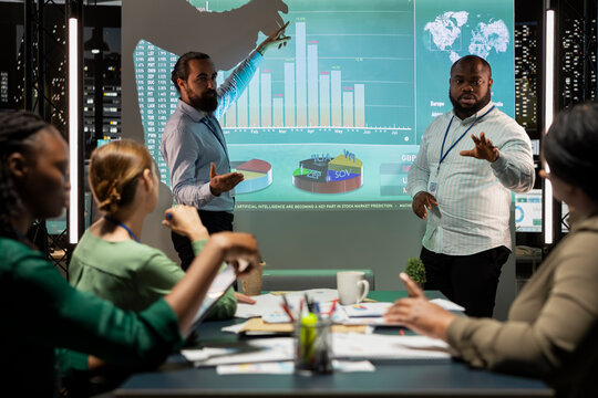 Diverse administrative team sharing insight on data in night time meeting at the office, providing proposals to enhance operational performance and efficiency. Business associates in boardroom.