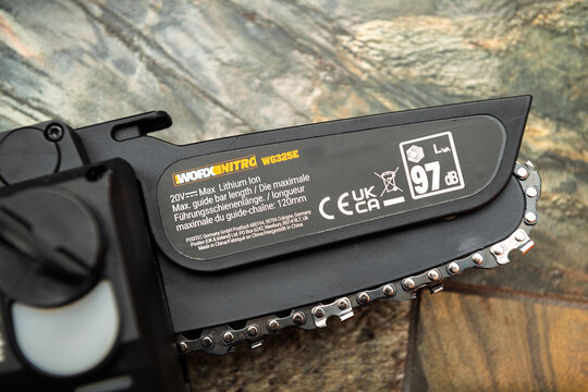 Paris, France - Apr 22, 2025: Detailed close-up of the Worx Nitro WG325E pruning saw shows product labeling with 120mm bar length 20V lithium-ion power rating and 97 dB noise level markings