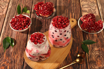 Pomegranate yogurt with berries in a glass on an elegant table, fruit salad, detox diet and natural nutrition concept, healthy breakfast with ingredients.advertisement of a healthy lifestyle