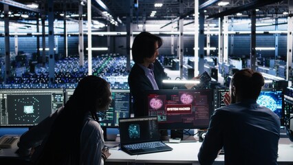 Engineers in AI server hub alerted by hacking incident involving theft of sensitive data. Teamworking data center employees alarmed by computer virus triggered by security systems, camera A