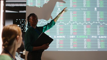 African american consultant presenting budget numbers and financial situation with advisory board, discussing new strategy to ensure organizational growth. After hours reporting. Camera B.