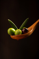 Olive branch soaked in olive oil on a wooden spoon