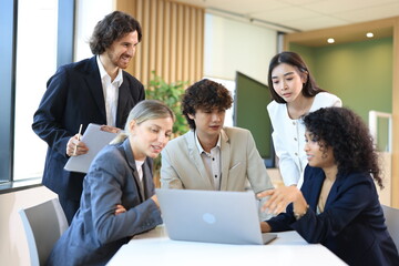 Fototapeta premium Diverse Team Working Together in Modern Co-Working Space. Casual meeting of smiling diverse business team analyzing financial data. Multiethnic business people working together in the office.