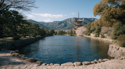 Scenic Japanese Landscape with Pagoda, Lake, Trees and Mountains Under Blue Sky