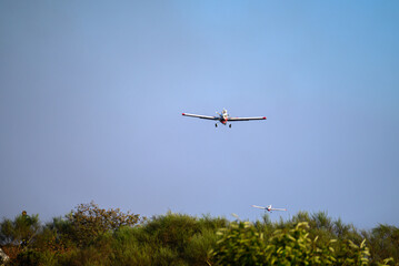 Two Firefighting Planes Flying Low Over a Forest. Concept A coordinated aerial attack.