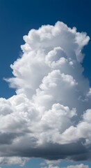 Obraz premium A fluffy cumulus cloud in a bright blue sky. The cloud is a towering formation, soft, and fluffy