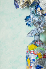 Plastic bottle eco-brick filled with waste on light background