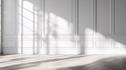 Fototapeta premium Sunlight casts shadows on a white wall with decorative molding in an empty room.