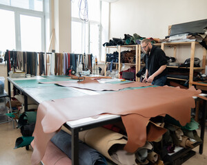 Caucasian bearded man working as a tanner in a workshop. 