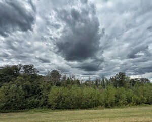 Dramatic storm clouds over lush green forest