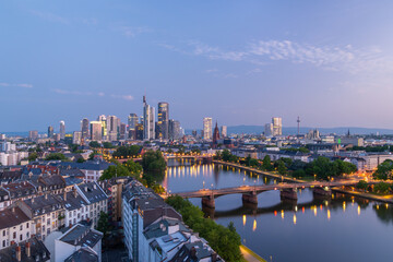 Obraz premium Illuminated Frankfurt City Downtown, Residential Buildings, Bridges and Main River at Morning Twilight. Wide Shot. Aerial View. Blue Hour. Hesse, Germany