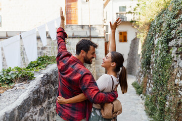 Happy couple enjoying a romantic moment outdoors, hugging and smiling in an old European stone street