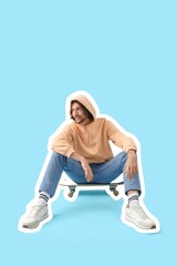 Obraz premium Young man sitting on skateboard against blue background