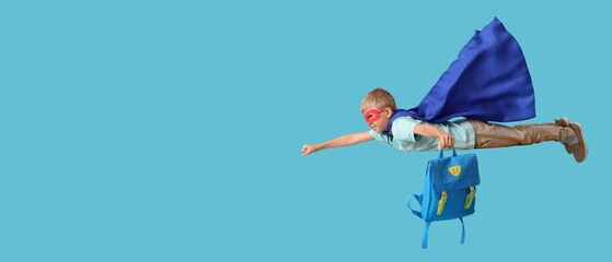 Flying little boy dressed as superhero with school backpack on blue background with space for text