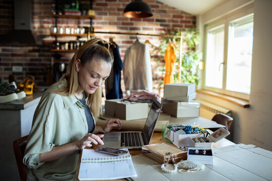 Young woman packaging jewelry for online second hand store at home