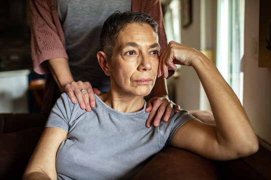 Stressed woman receiving comforting support from her lesbian partner at home