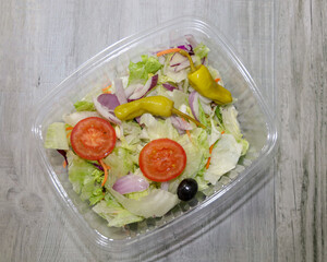 Top view of a prepackaged salad mix in a compostable container.