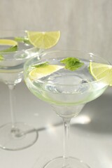 Martini cocktails with lime and mint on grey table, closeup