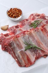 Fresh raw beef ribs and spices on white table, closeup