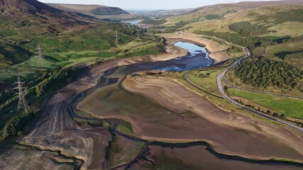 Stunning aerial footage reveals the impact of drought on Woodhead Reservoir in Derbyshire, showcasing significantly low water levels and exposed dry ground. This parched landscape highlights pressing 