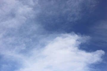 A clear blue sky with thin white clouds