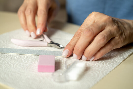 Nail care at home, close-up manicure. Using cuticle nippers, a nail file, a sanding pad, a brush and an orange stick.