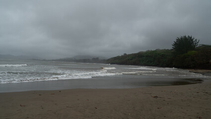 Dramatic storm clouds over rustic beach huts and shoreline at Roca Partida, Veracruz, Mexico.