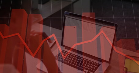 Displaying spreadsheet on laptop at office desk with phone, yellow notebook and red graph overlay