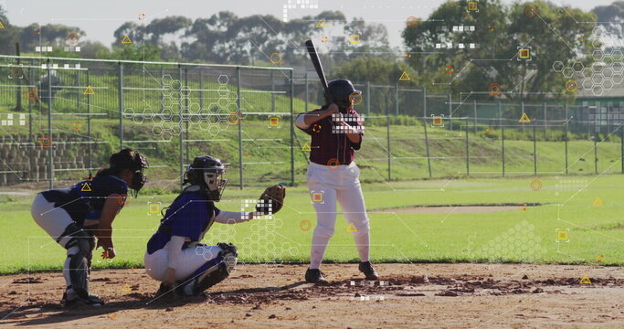 Batter gripping bat preparing swing at home plate on softball field, with catcher wearing mitt