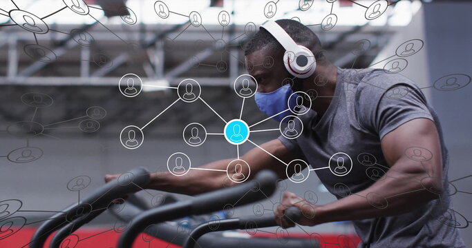 Gripping stair-climber, man wearing gray T-shirt blue mask and headphones at gym with data overlay