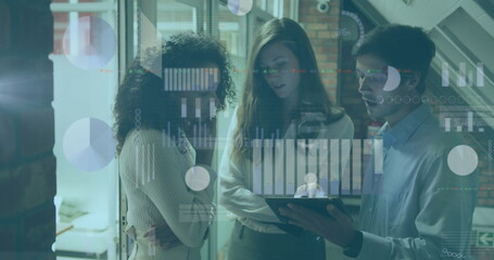 Three professionals wearing business casual analyzing data charts on tablet in office