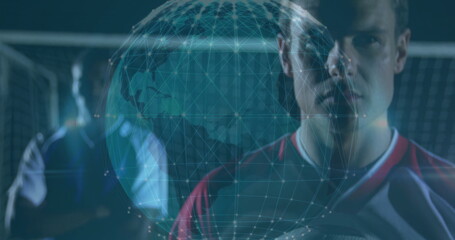 Red-shirted player holding soccer ball on pitch, with net and wireframe globe overlay, copy space