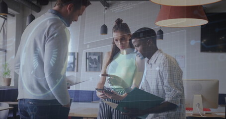 Collaborating coworkers reviewing tablet and folder in open plan office with holographic overlay