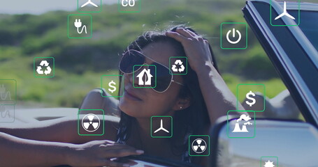 Leaning Indian woman brushing hair out of convertible at rural roadside, with green energy icons