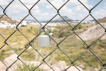 A padlock on a steel fence, a padlock of love, a pact, an agreement.
