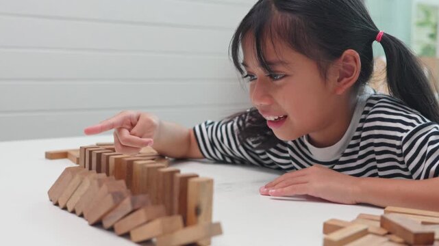 Focused girl playing and learning with wooden blocks