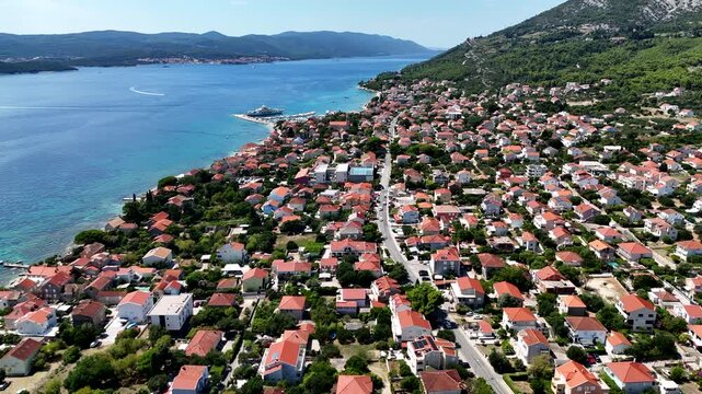 Aerial view of a beautiful blue ocean with a small town on the shore.