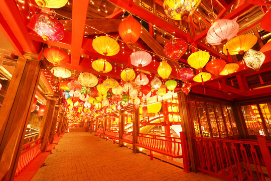 In winter, the long corridor by the river is decorated with Chinese lanterns， Chinese festive lantern at night