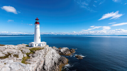 Stunning lighthouse stands tall by rocky coastline, surrounded by calm blue waters and clear sky