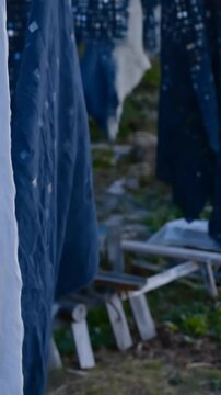 Drape of navy fabric adorned with small square patches, hung to dry outdoors