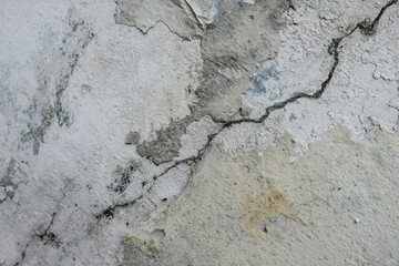Old wall with peeling paint, cracks, and weathered surface. Useful as a background, texture, or concept image for themes such as decay, aging, renovation, construction, damage, and imperfection