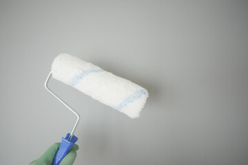 Painting a wall with a roller in a home interior