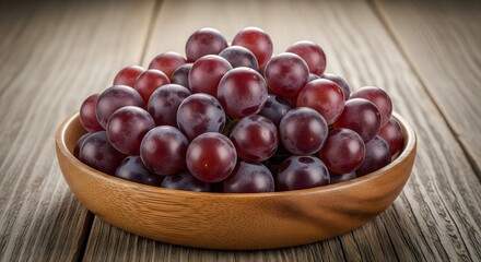 Obraz premium A Bowl of Fresh Red Grapes on Wooden Table
