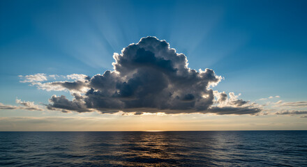 Sunbeams Breaking Through a Dramatic Cumulus Cloud Over the Ocean at Sunset