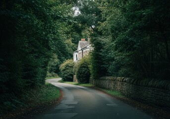 Fototapeta premium Road leading to house through forest with stone wall, a peaceful countryside landscape in nature