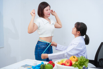A middle-aged Asian female dietitian conducts a health consultation with a middle-aged Asian female...